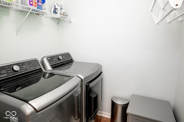 washroom featuring dark wood-style flooring, separate washer and dryer, and laundry area