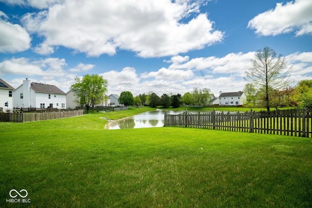 view of yard featuring fence and a water view