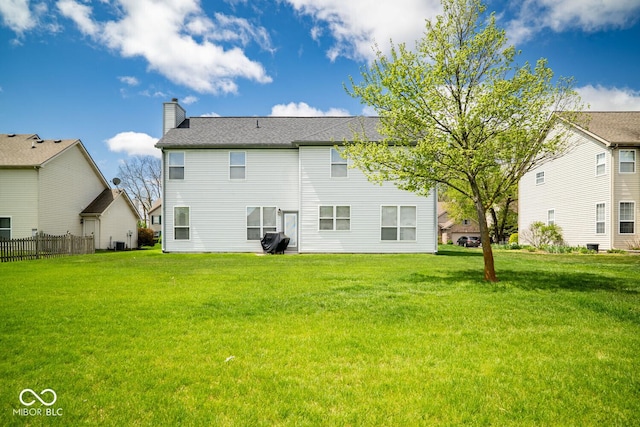 back of house featuring a lawn, fence, a chimney, and central AC unit