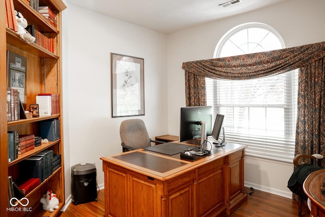 office space featuring visible vents, dark wood finished floors, and baseboards