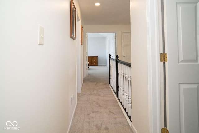 hallway with recessed lighting, light colored carpet, and baseboards