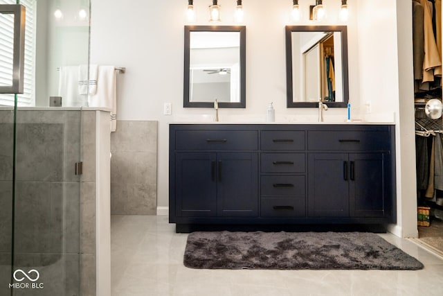 full bath with a tile shower, double vanity, and a sink
