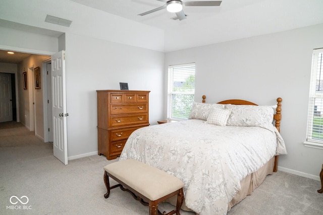 bedroom featuring visible vents, baseboards, a ceiling fan, and light carpet