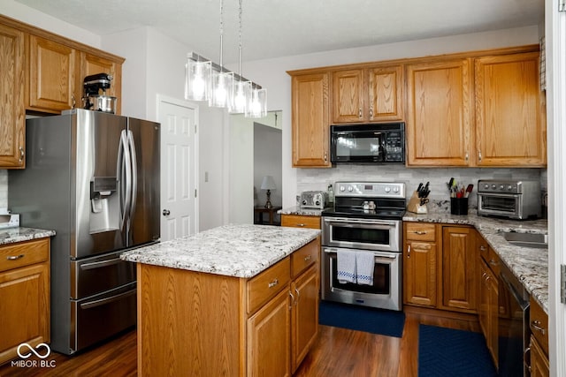 kitchen featuring appliances with stainless steel finishes, brown cabinetry, dark wood finished floors, and backsplash