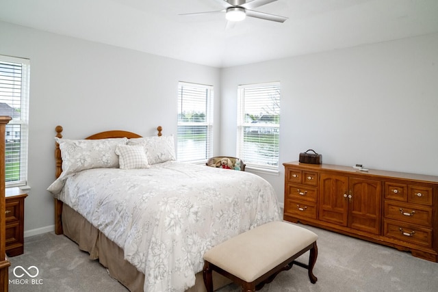 bedroom with light colored carpet, ceiling fan, and baseboards