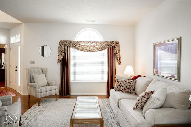 living area with visible vents, wood finished floors, and baseboards