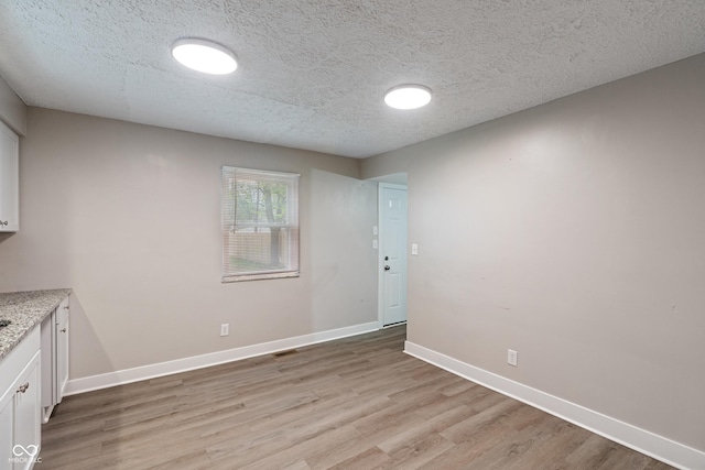 2935 Highland Pl, Indianapolis, IN 46208 - unfurnished dining area featuring a textured ceiling, light wood-style floors, visible vents, and baseboards