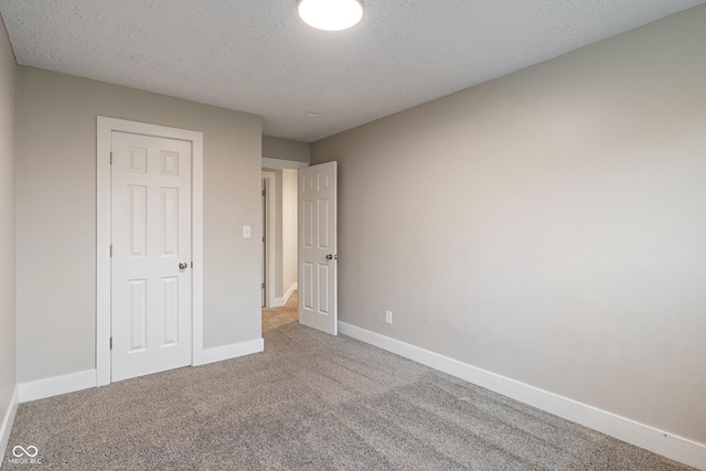 2935 Highland Pl, Indianapolis, IN 46208 - unfurnished bedroom with baseboards, a textured ceiling, and carpet