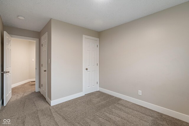 2935 Highland Pl, Indianapolis, IN 46208 - unfurnished bedroom with baseboards, a textured ceiling, and carpet flooring