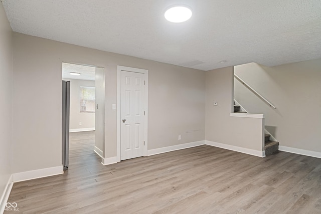 2935 Highland Pl, Indianapolis, IN 46208 - unfurnished living room with a textured ceiling, stairway, wood finished floors, and baseboards