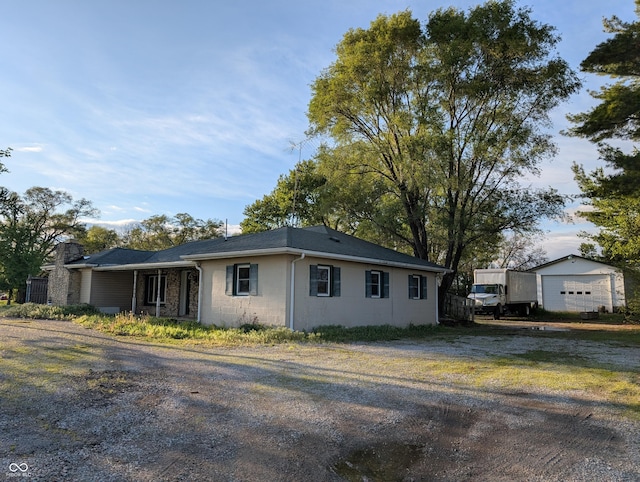 view of front of house with dirt driveway and an outbuilding