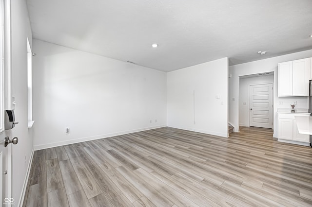 7265 Governors Row, Avon, IN 46123 - unfurnished living room featuring light wood-type flooring, recessed lighting, and baseboards