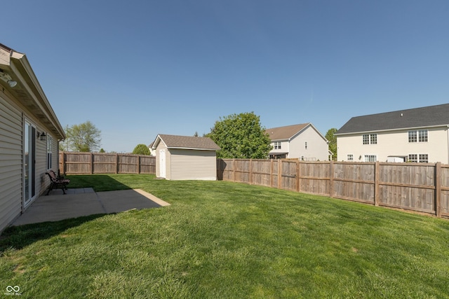 view of yard featuring a fenced backyard, a patio, and an outbuilding
