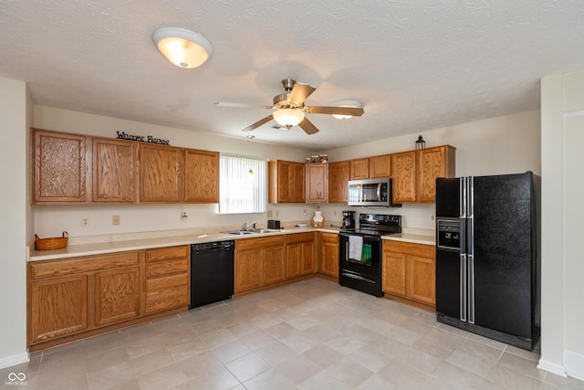 kitchen with light countertops, a ceiling fan, a sink, and black appliances