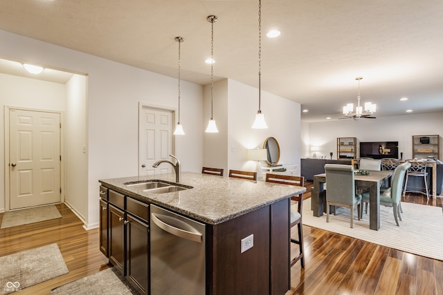 kitchen featuring a sink, dark wood-style flooring, a breakfast bar, dishwasher, and open floor plan