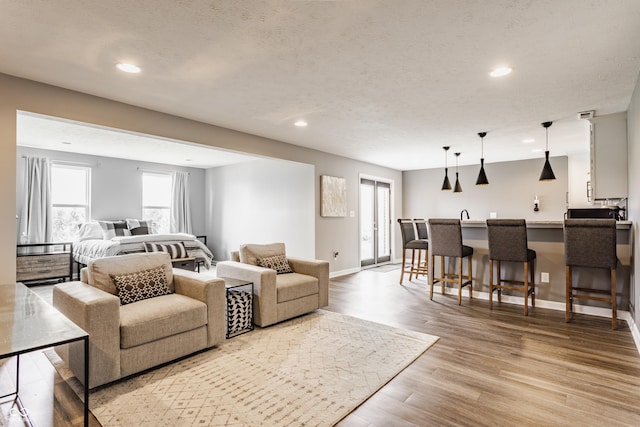 living room featuring baseboards, recessed lighting, wood finished floors, and plenty of natural light