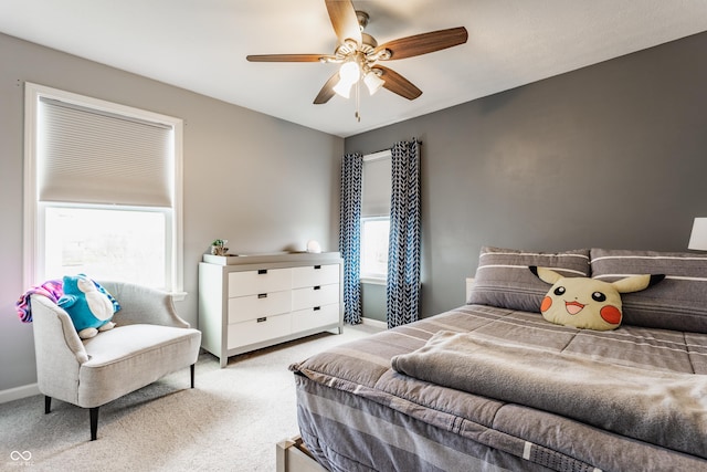 carpeted bedroom with a ceiling fan and multiple windows
