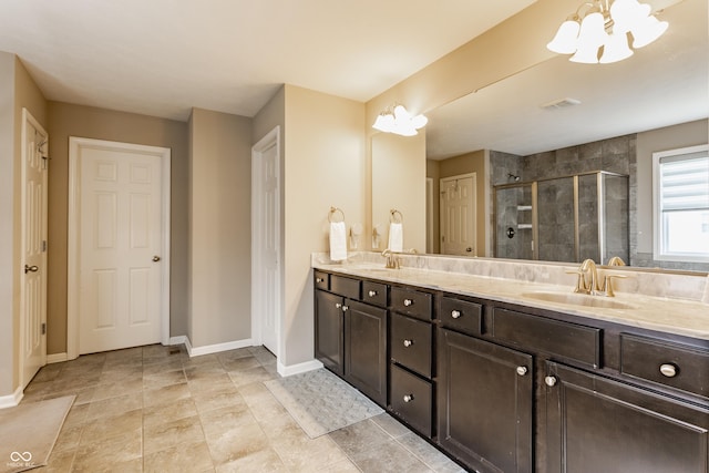 full bathroom with baseboards, a shower stall, double vanity, and a sink