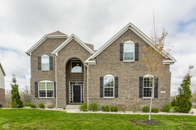 view of front of house with a front lawn and brick siding