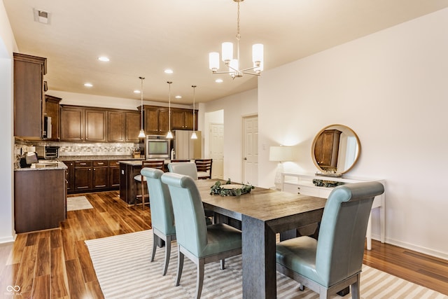 dining area with visible vents, baseboards, an inviting chandelier, recessed lighting, and dark wood finished floors