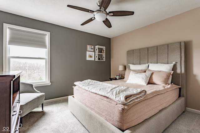 carpeted bedroom with ceiling fan and baseboards