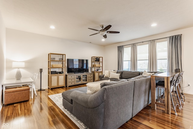 living area with recessed lighting, a ceiling fan, and wood finished floors