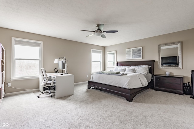 carpeted bedroom featuring baseboards and a ceiling fan