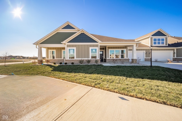 craftsman inspired home with board and batten siding, driveway, and a front yard