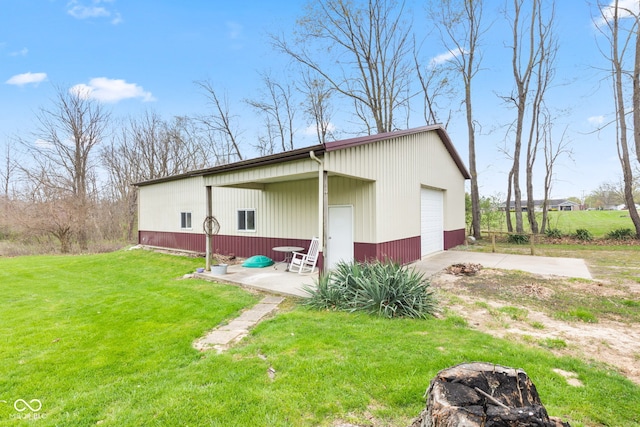 1301 N Maple St, Veedersburg, IN 47987 - back of property featuring concrete driveway, an outbuilding, a yard, and a detached garage