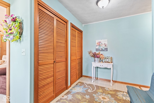 1301 N Maple St, Veedersburg, IN 47987 - hallway with ornamental molding, baseboards, a textured ceiling, and light tile patterned floors