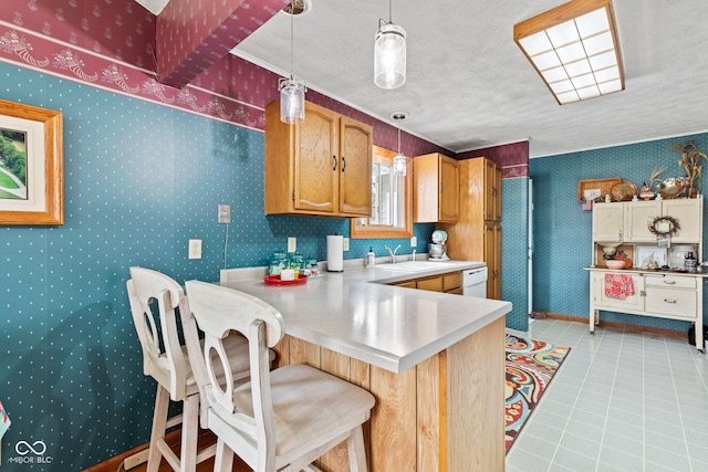 1301 N Maple St, Veedersburg, IN 47987 - kitchen with wallpapered walls, light countertops, dishwasher, a sink, and pendant lighting