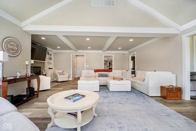 living room with recessed lighting, wood finished floors, visible vents, beamed ceiling, and a fireplace