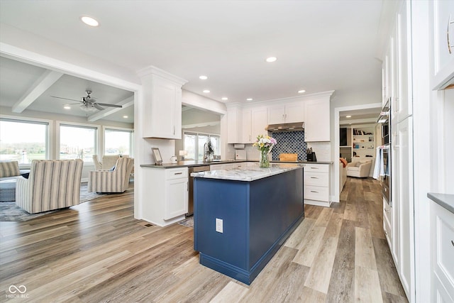 kitchen featuring ceiling fan, white cabinetry, a center island, and light wood-type flooring