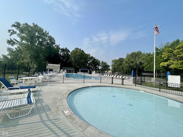community pool featuring fence and a patio area