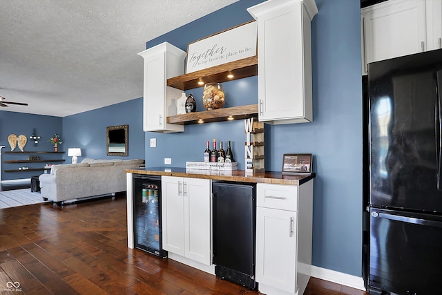 13836 Fieldcrest Dr, Mccordsville, IN 46055 - kitchen with wine cooler, dark wood-style floors, a textured ceiling, freestanding refrigerator, and white cabinetry