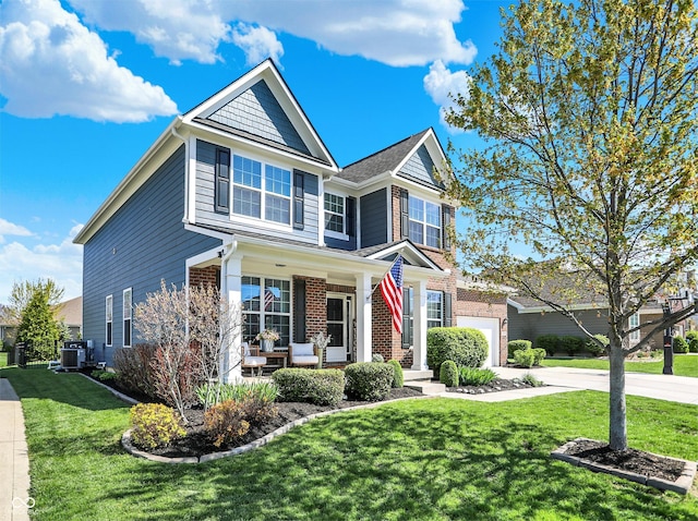 13836 Fieldcrest Dr, Mccordsville, IN 46055 - view of front of property featuring a front lawn, cooling unit, driveway, a porch, and brick siding