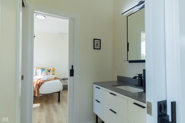 2302 Prospect St, Indianapolis, IN 46203 - ensuite bathroom featuring wood finished floors, visible vents, vanity, and ensuite bathroom
