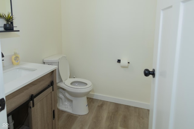 2302 Prospect St, Indianapolis, IN 46203 - half bathroom featuring baseboards, wood finished floors, toilet, and vanity