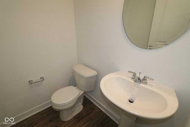 3832 Highcrest Rd, Indianapolis, IN 46239 - bathroom with baseboards, a sink, toilet, and wood finished floors