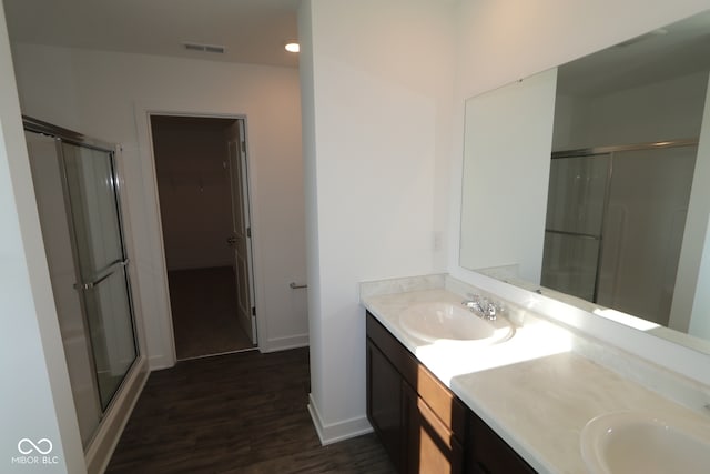 3832 Highcrest Rd, Indianapolis, IN 46239 - full bath with a stall shower, wood finished floors, a walk in closet, double vanity, and baseboards