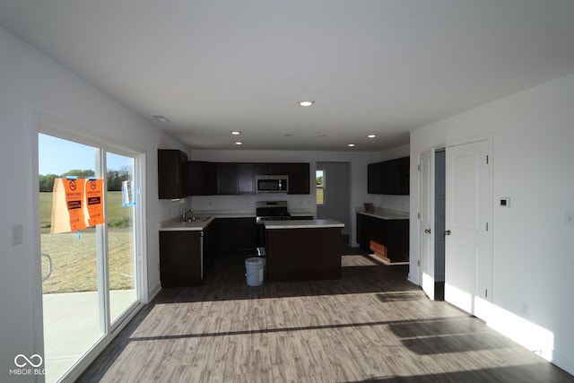 3832 Highcrest Rd, Indianapolis, IN 46239 - kitchen featuring appliances with stainless steel finishes, a sink, dark cabinets, wood finished floors, and light countertops