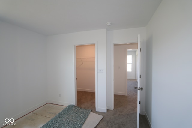 3832 Highcrest Rd, Indianapolis, IN 46239 - unfurnished bedroom with a walk in closet, baseboards, a closet, and carpet floors