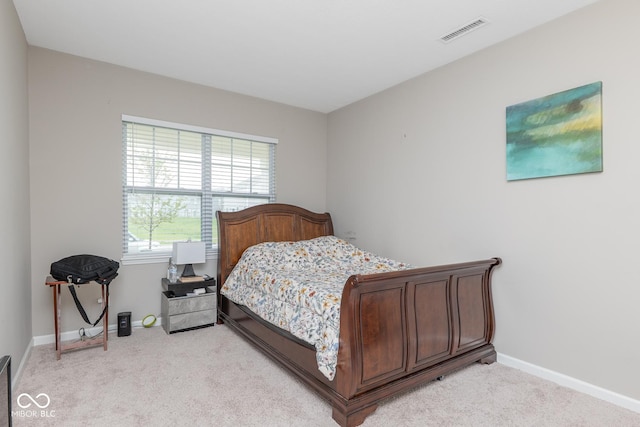 bedroom featuring visible vents, light carpet, and baseboards