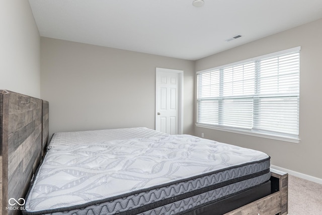 carpeted bedroom featuring baseboards and visible vents