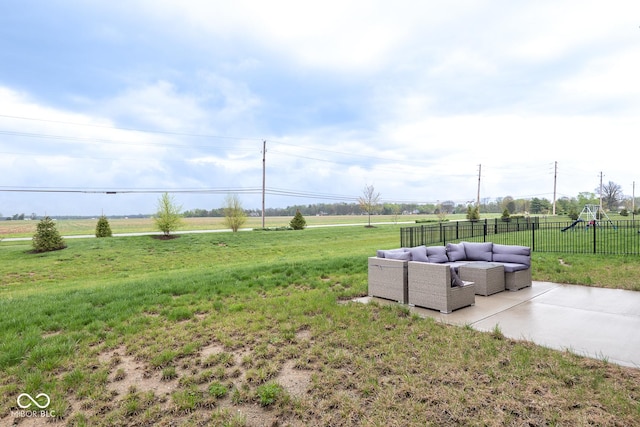 view of yard with outdoor lounge area, fence, a rural view, and a patio area