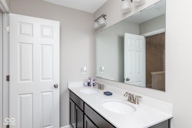 bathroom featuring double vanity, visible vents, and a sink