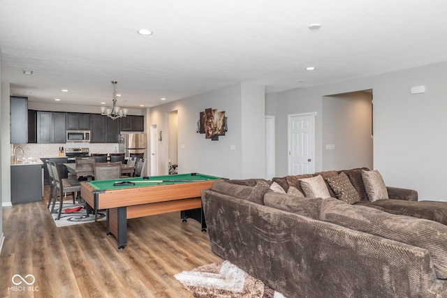 playroom with recessed lighting, a notable chandelier, light wood-style flooring, and pool table