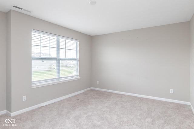unfurnished room featuring visible vents, baseboards, and light carpet