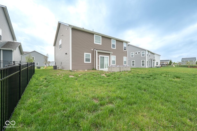 back of property featuring fence, a yard, and central air condition unit