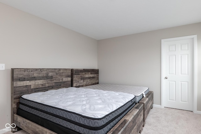 bedroom featuring baseboards and light colored carpet